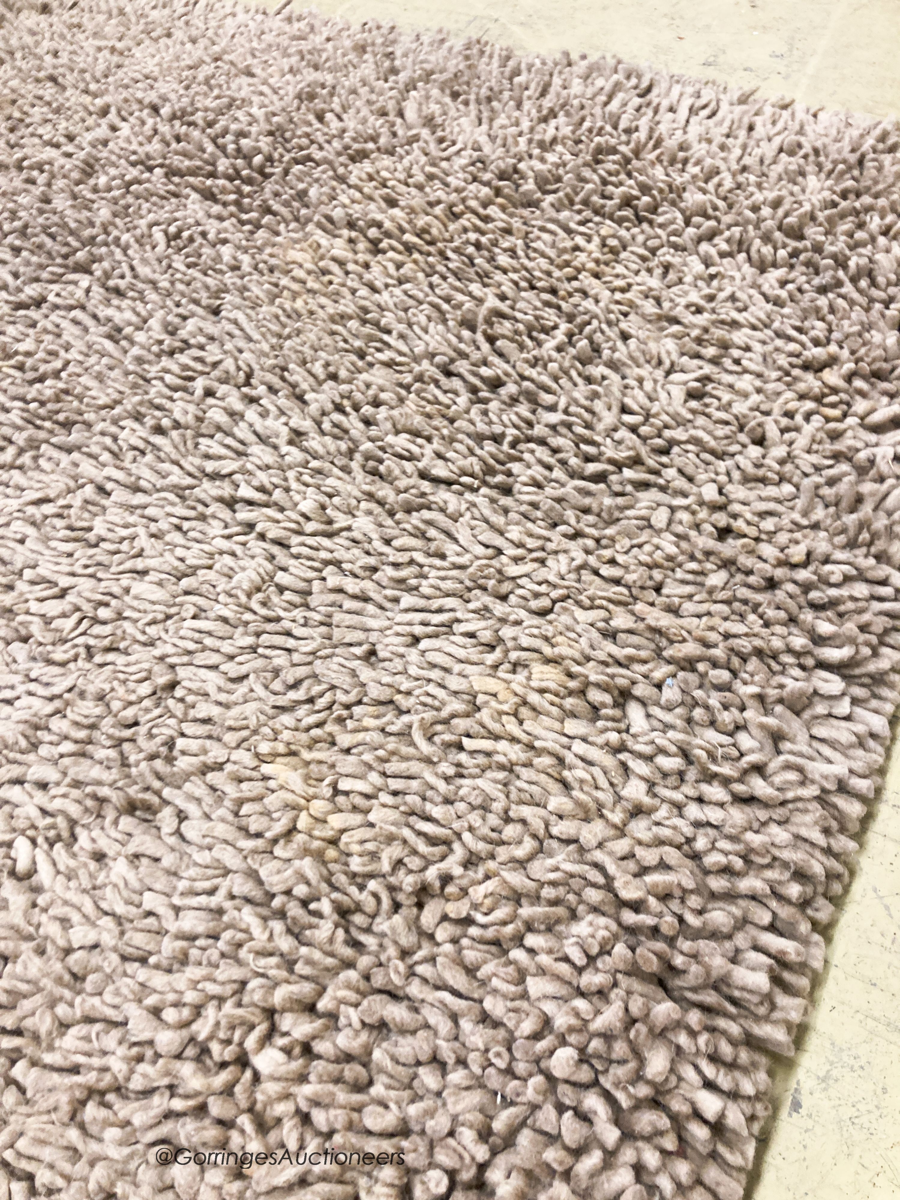 A contemporary brown shag pile carpet, 300 x 200cm
